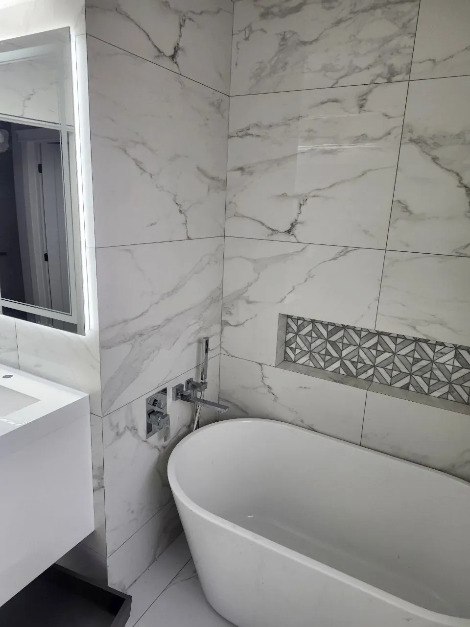 Marble bathroom with freestanding tub and mosaic niche by NovoTile, Greater Victoria