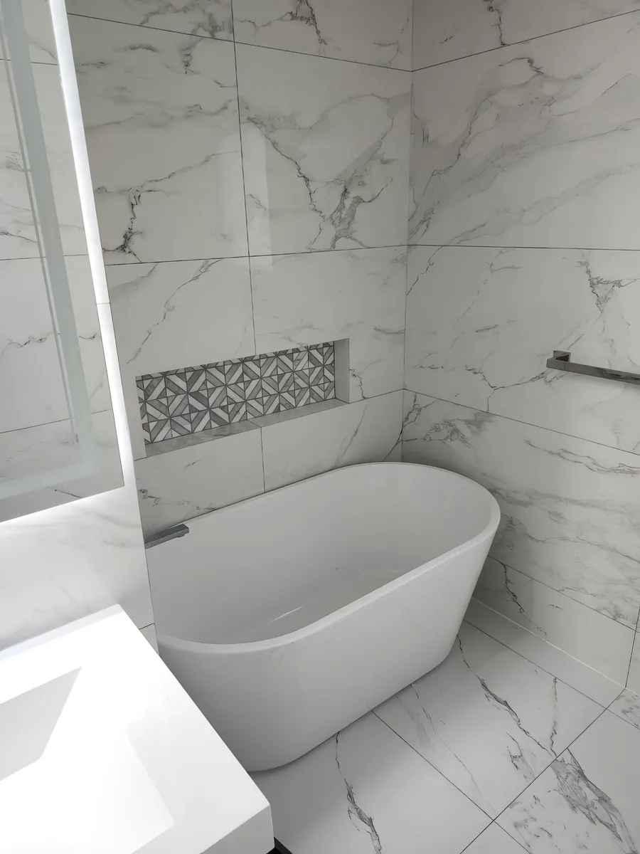 Walk-in shower with a floating bench and marble mosaic niche, tiled by Novo Tile in Saanich BC