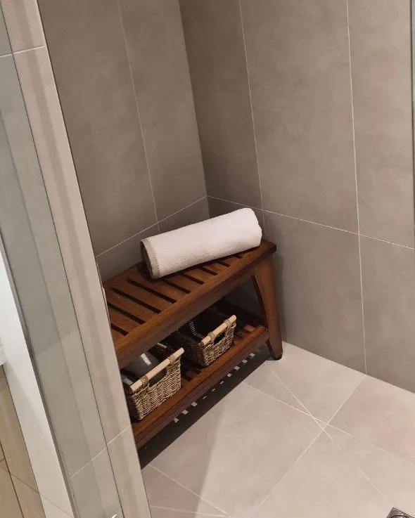 Large-format porcelain shower with diagonal floor cuts sloped to the drain