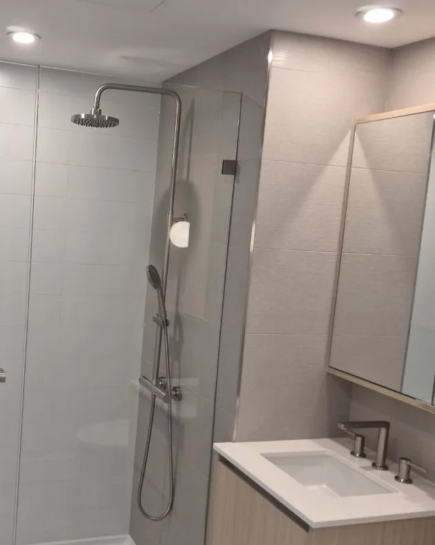 Condo shower with frameless glass, rain head and tiled walls, Greater Victoria