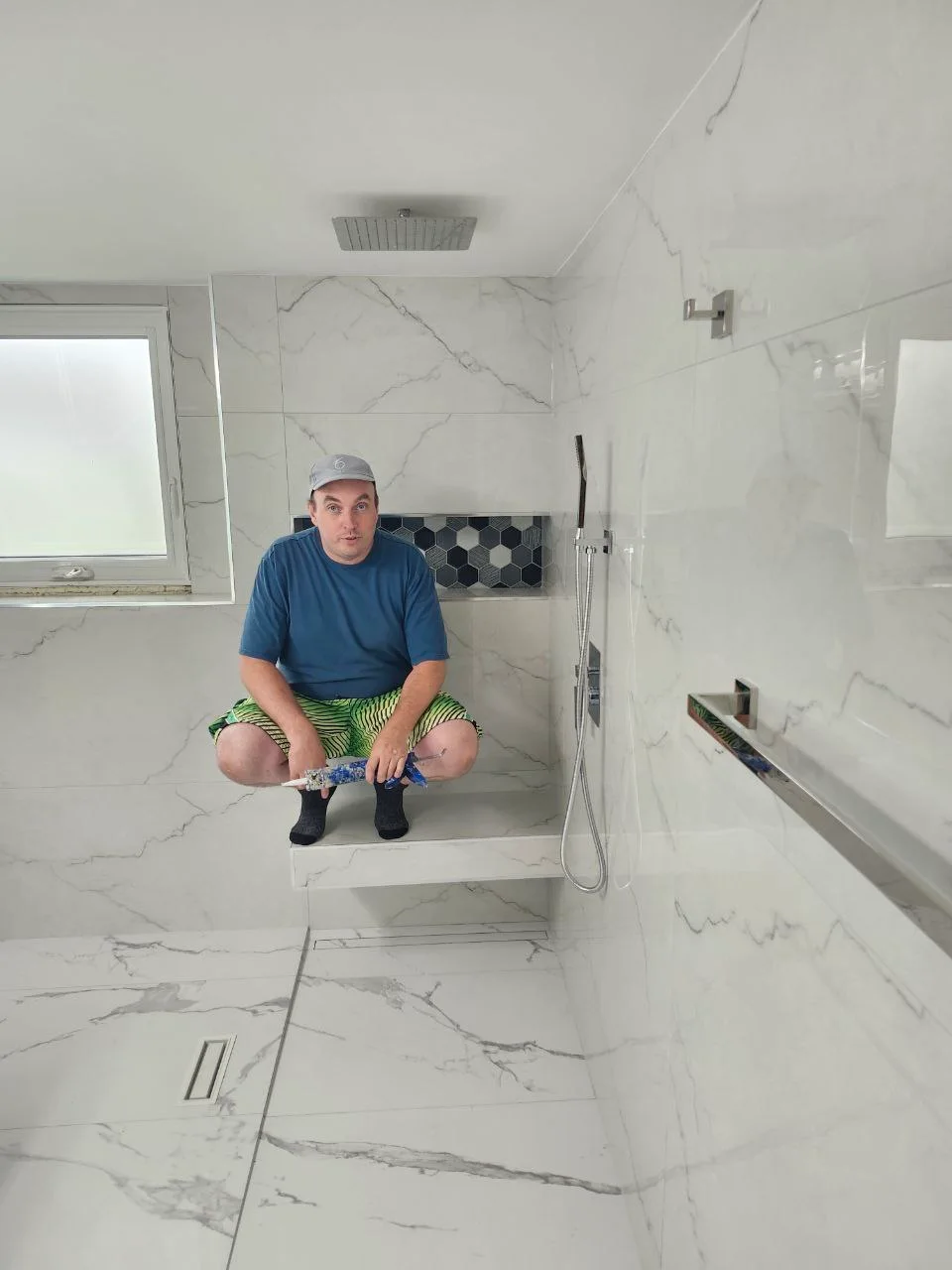 Vova, owner of Novo Tile, on the floating bench of a walk-in shower he just finished